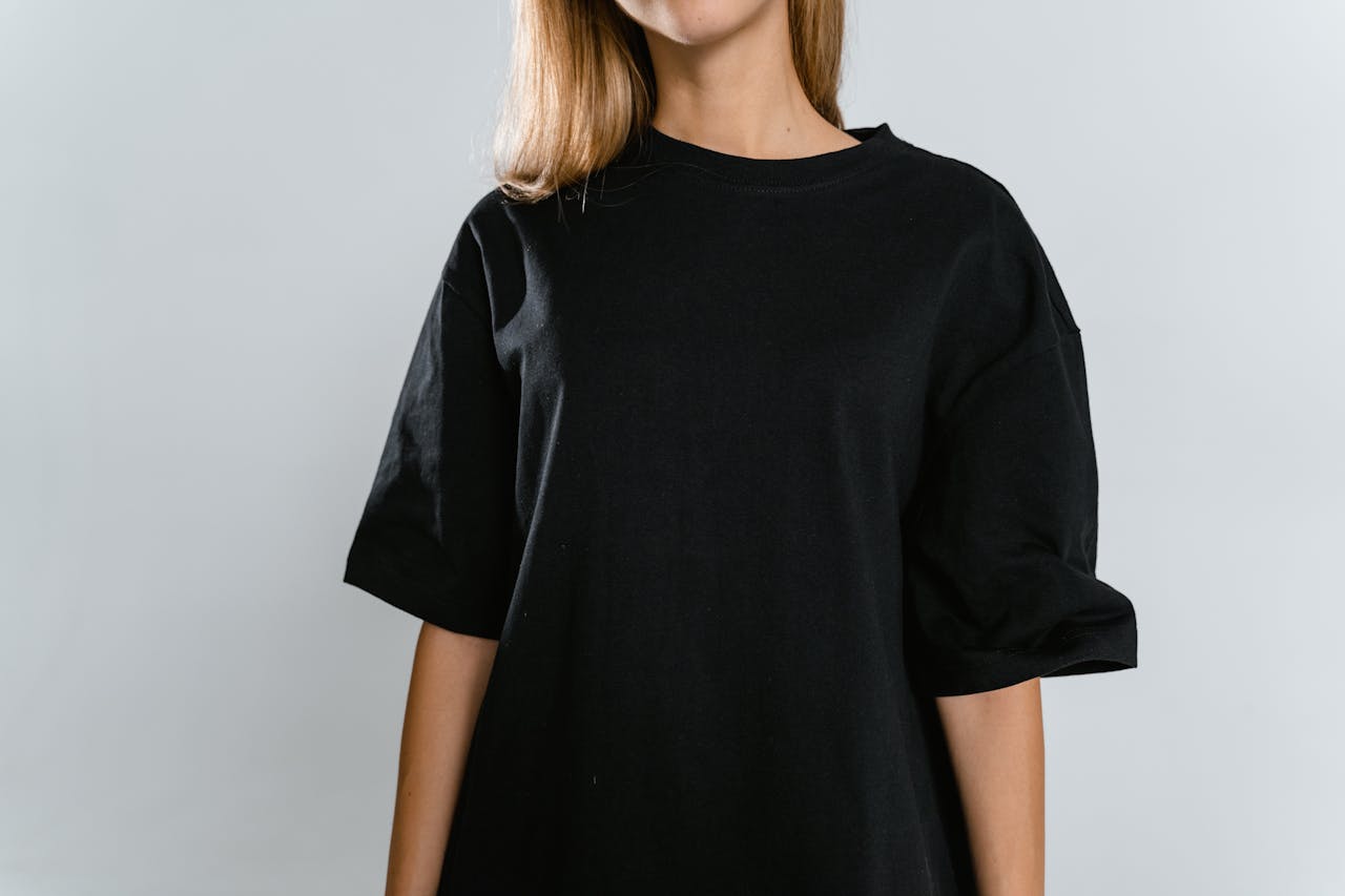 About Front view of woman wearing black t-shirt with copy space on white background.
